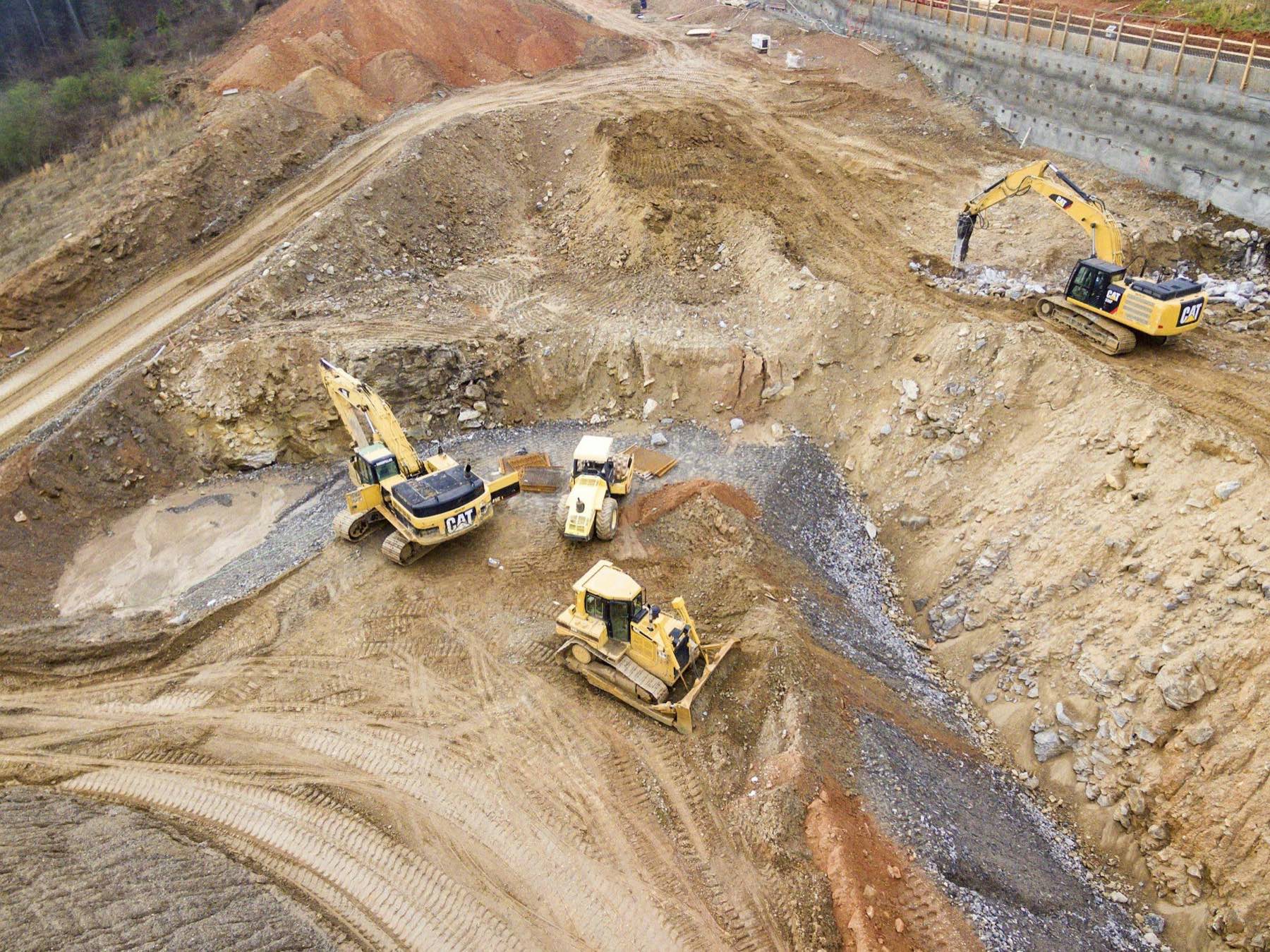 Aerial view of an excavation site with excavators and earth-moving machinery